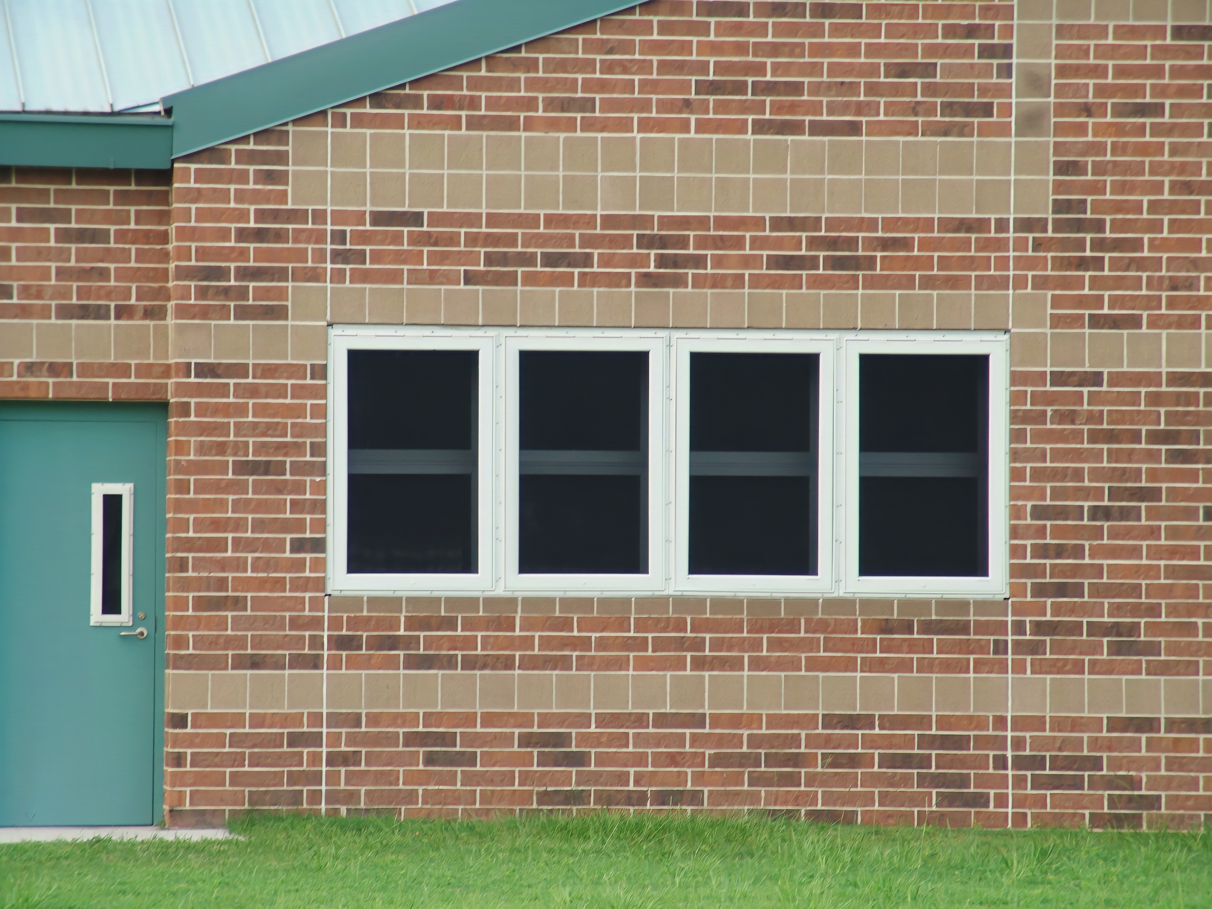 an image of a school exterior with remini-enhanced security screens installed on 4 window panel