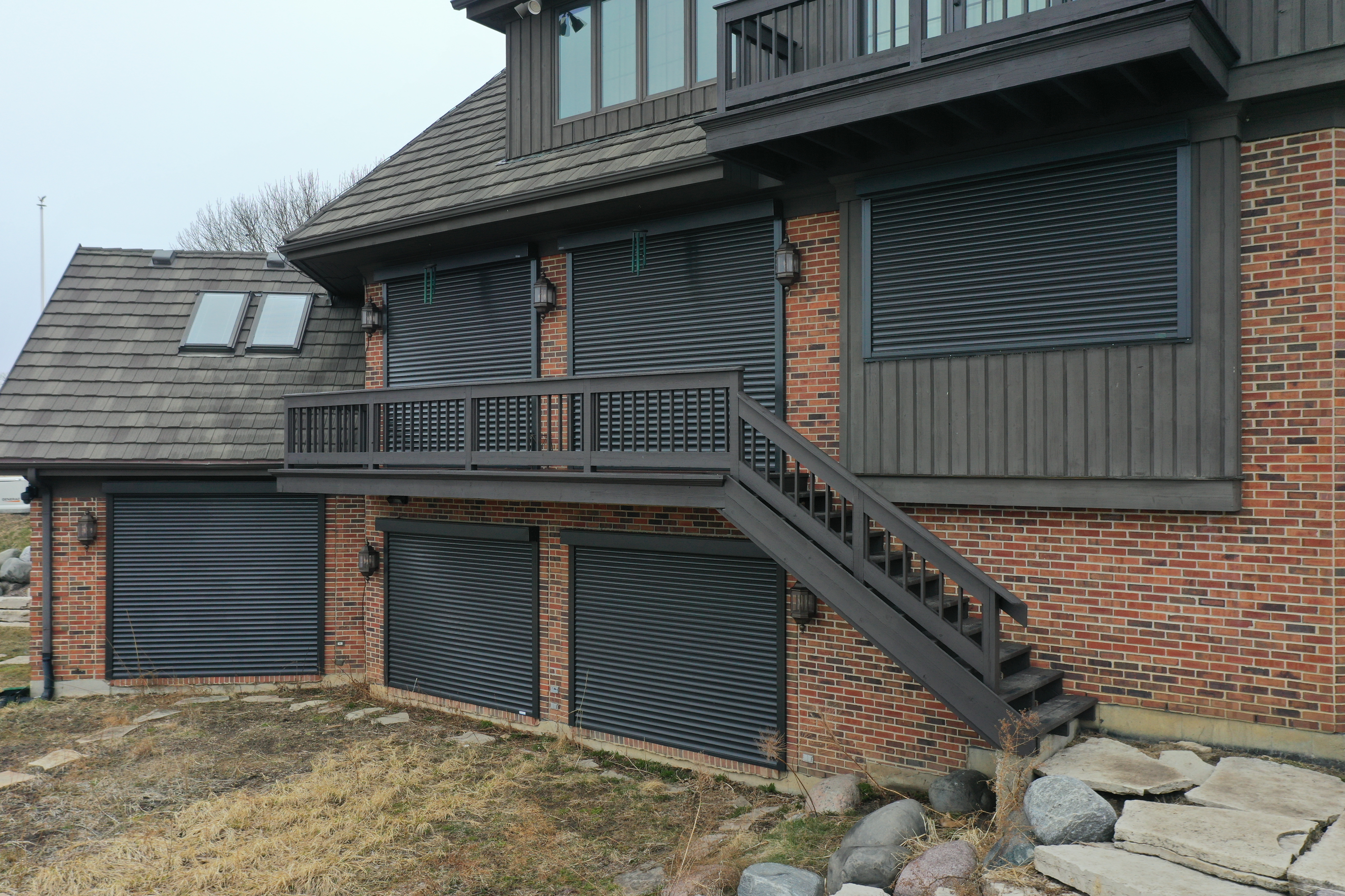 Metal shutters installed on the windows of a residential home - shutters are providing security and protection to the house