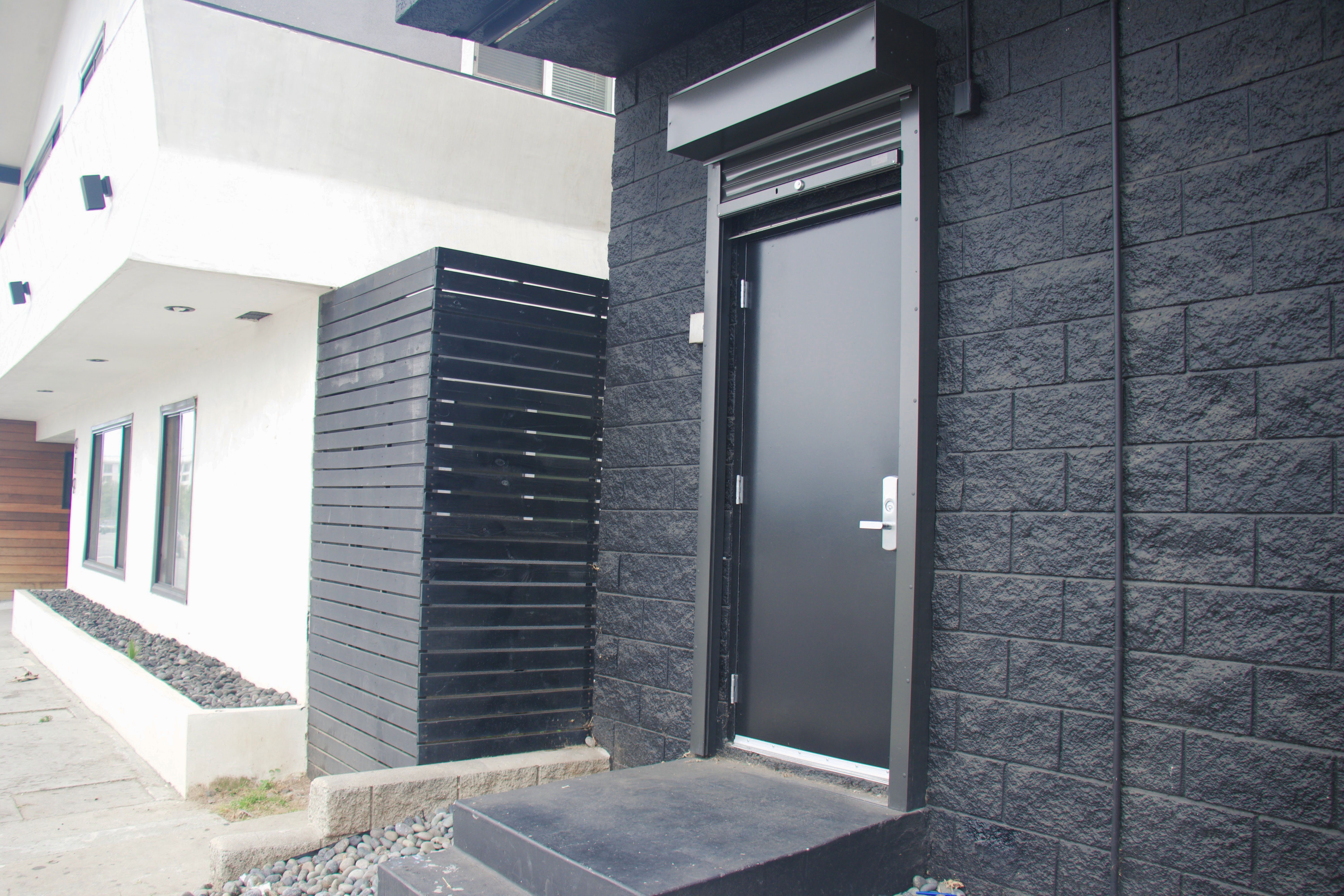 an exterior mounting security shutter protects a side exit door for a commercial building.