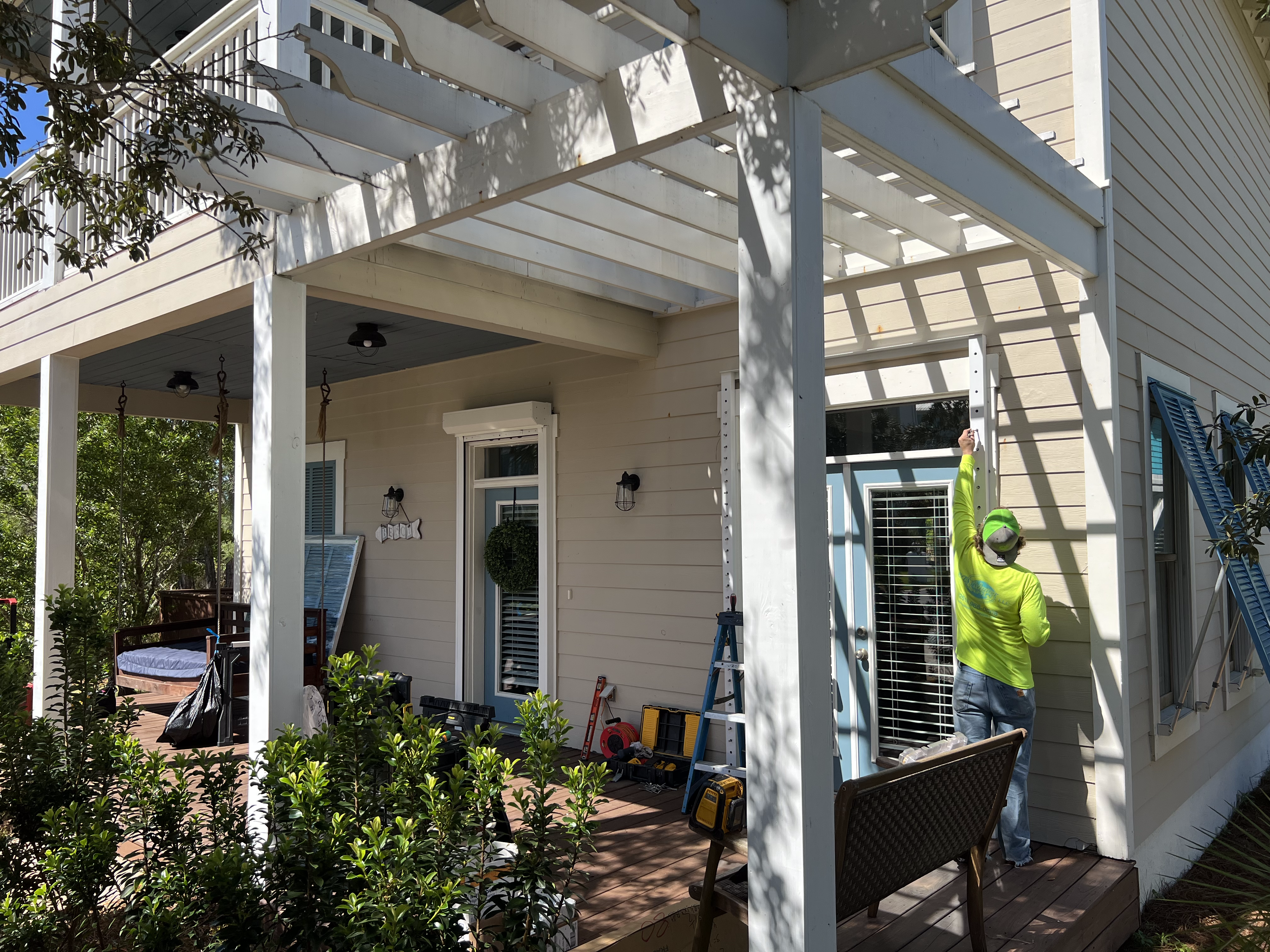 man installing shutters on a residential home