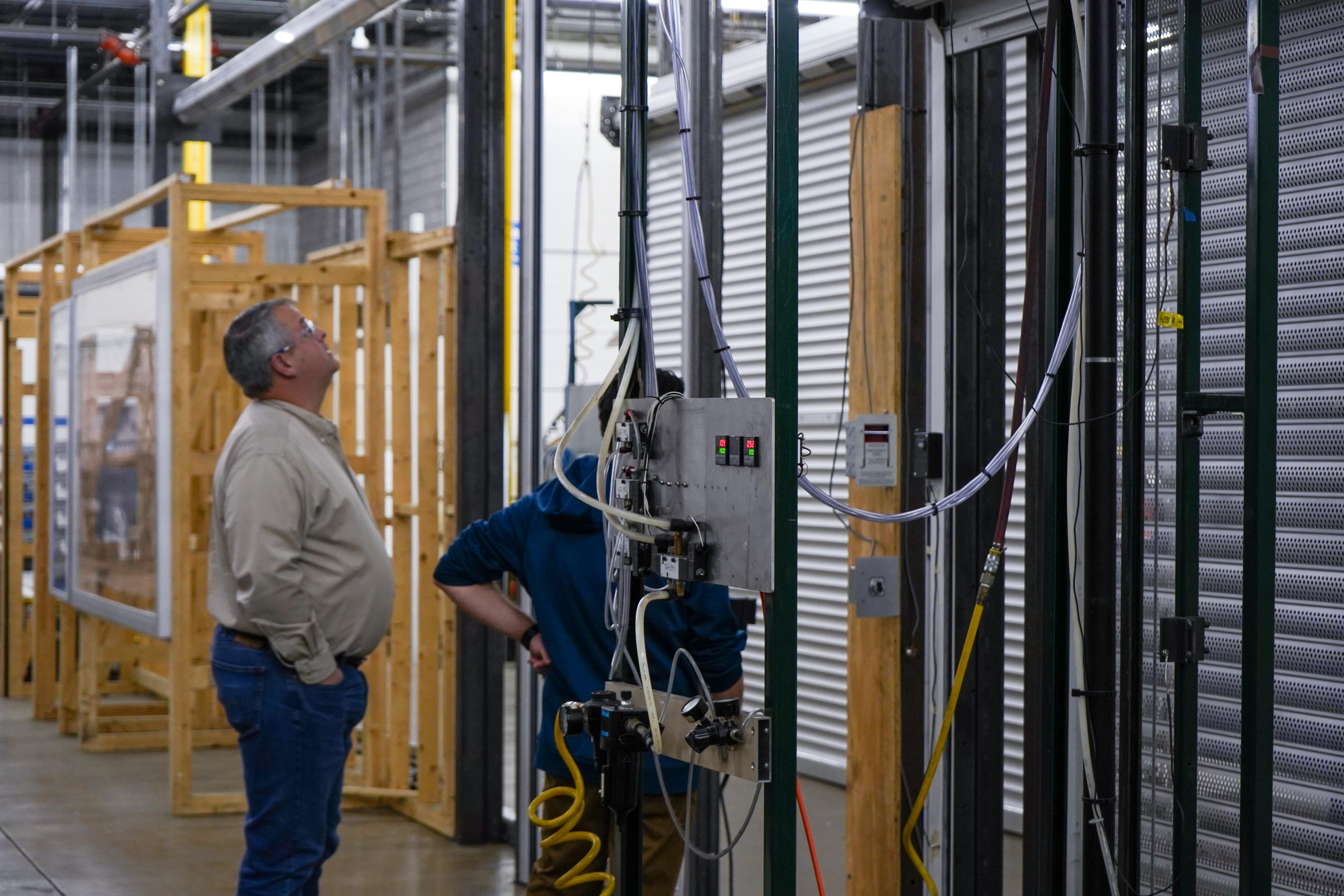 Image depicting a man conducting engineering testing for metal shutters.