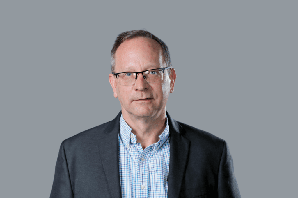 man with glasses wearing a blazer and button up