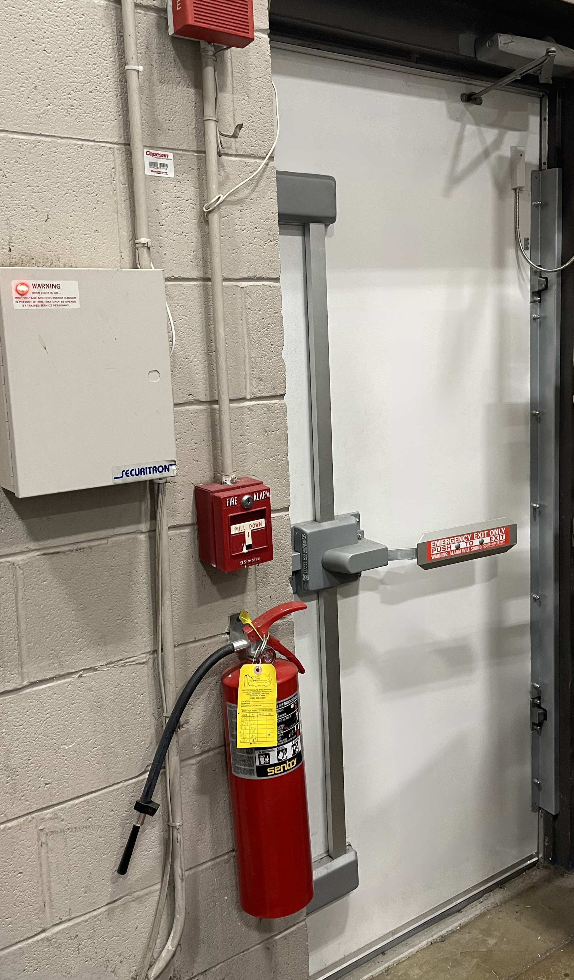 emergency exit on a security door next to a fire extinguisher